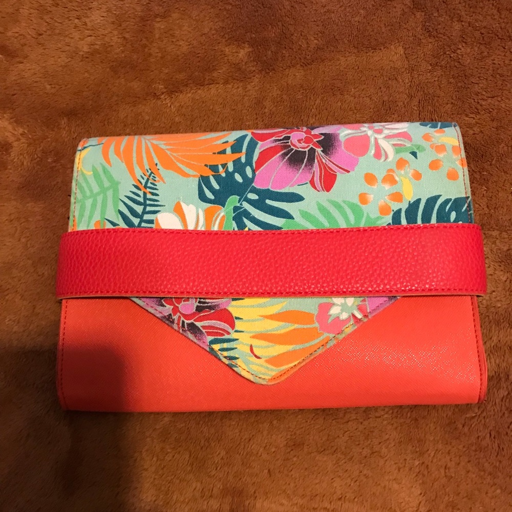 Never used clutch. Bright orange, Flower flap and tuck closer. Multi pockets.